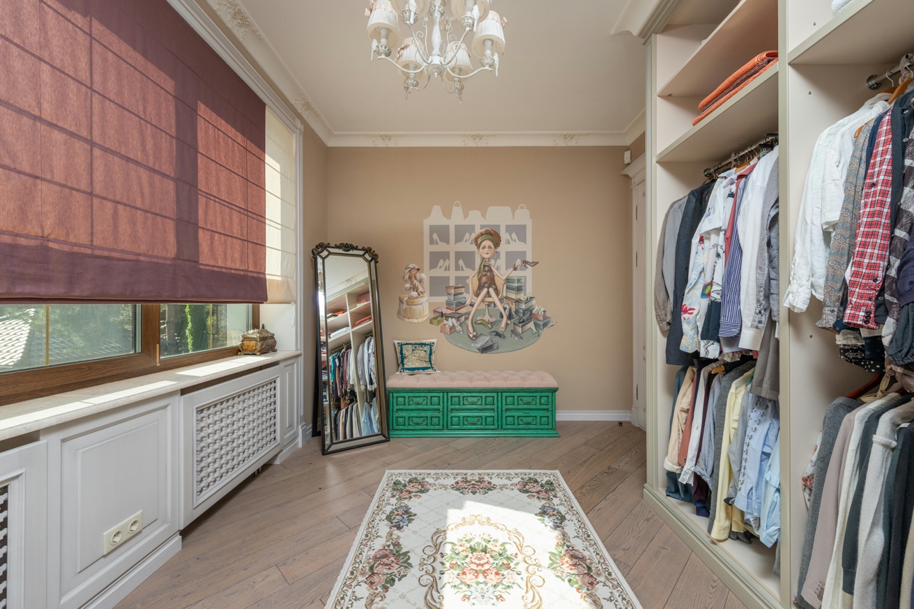 Walk-in closet with organized clothing and full-length mirror